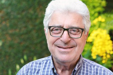 Dışında oturan yaşlı bir adam.