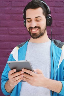 Bir tablet kullanan genç latin adam portresi