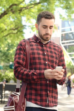 Telefonunu yazarak adam.