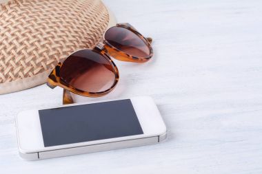 Bir smartphone ve bir şapka ile güneş gözlüğü.