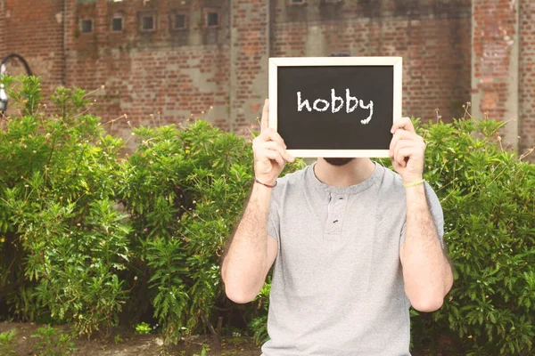 Homem segurando quadro com texto "hobby " — Fotografia de Stock