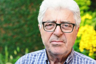 Dışında oturan yaşlı bir adam.