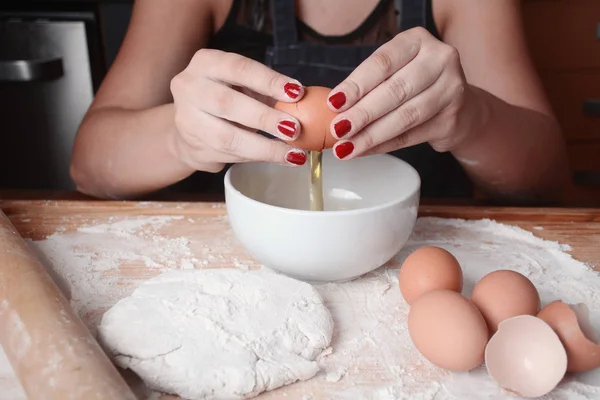 Frau bricht ein Ei in Schüssel. — Stockfoto