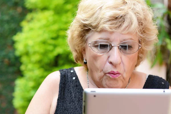 Bejaarde vrouw met behulp van Tablet PC. — Stockfoto