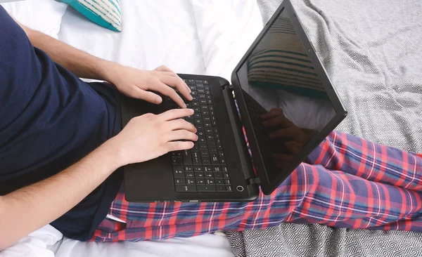 Людина використовує ноутбук у ліжку . — стокове фото