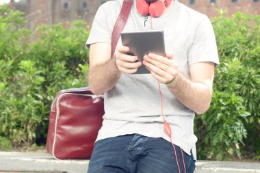 Genç adam tablet ile kulaklık kullanma.