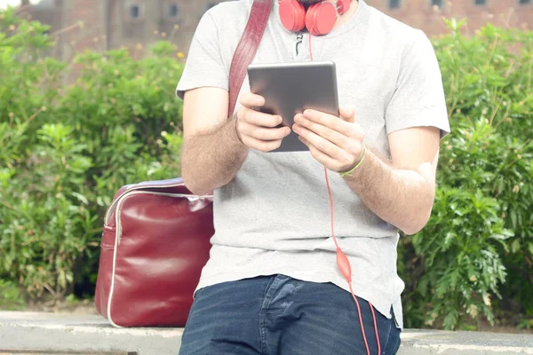 Genç adam tablet ile kulaklık kullanma.