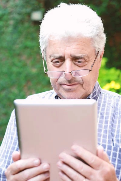 Homem velho usando tablet digital . — Fotografia de Stock