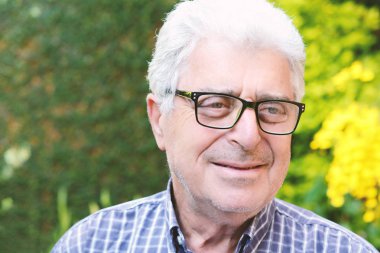 Dışında oturan yaşlı bir adam.