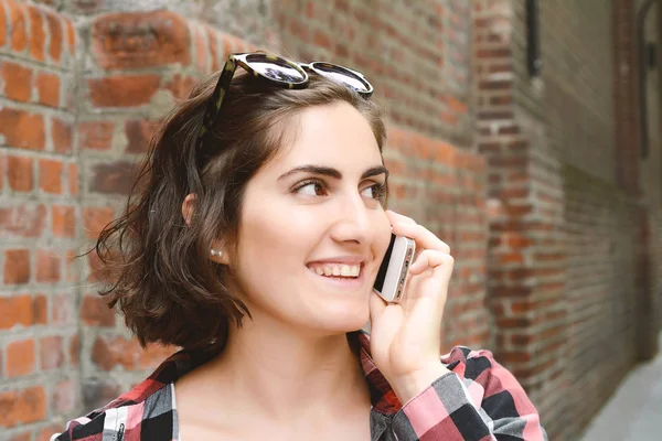 Porträtt av en ung kvinna som pratar i telefon. — Stockfoto
