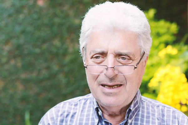 Dışında oturan yaşlı bir adam.