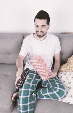 Patlamış mısır yemek ve film izlerken bir adam.