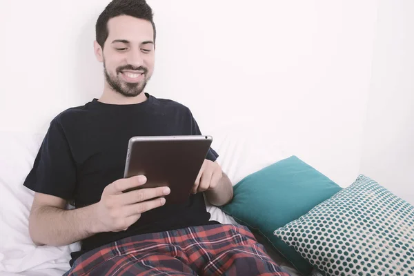 Hombre usando la tableta en la cama . — Foto de Stock