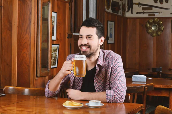 Bira içip bir barda atıştırmalıklar yemek Latince adam