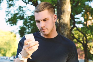 Onun akıllı telefon kullanan Latince adam. Açık havada.