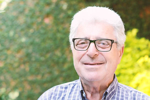 Dışında oturan yaşlı bir adam.