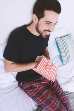 Patlamış mısır yemek ve film izlerken bir adam.