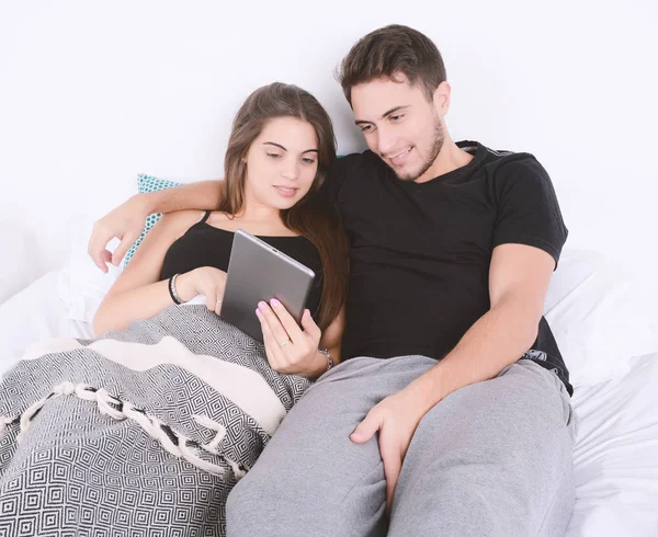 夫妇在床上使用平板电脑. — 图库照片