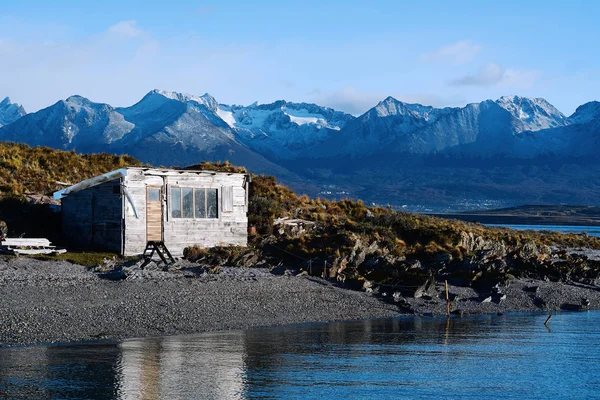 Casa no rio com montanhas nas costas . — Fotografia de Stock