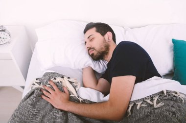 Adam yatakta uyuyor..