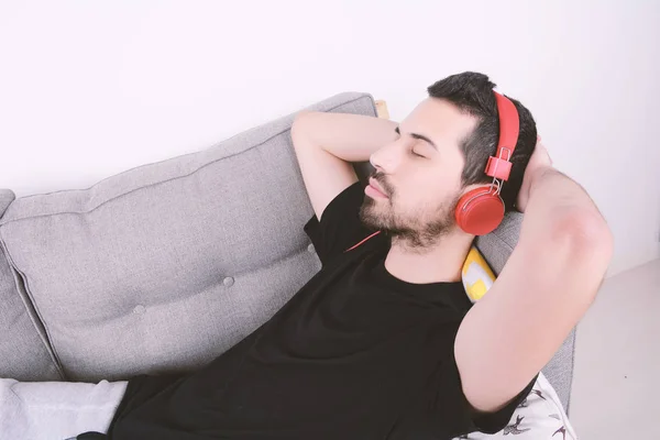 Homme écoutant de la musique sur canapé . — Photo