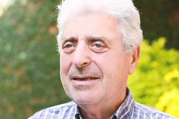 Dışında oturan yaşlı bir adam.