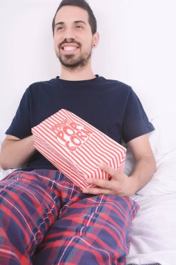 Patlamış mısır yemek ve film izlerken bir adam.