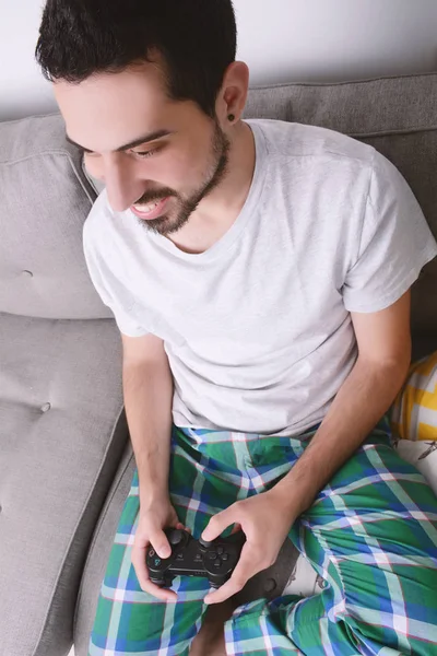 Homme jouant à des jeux vidéo et assis sur le canapé — Photo
