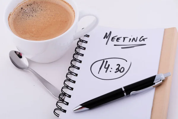 Bloco de notas com texto "REUNIÃO 14: 30" com xícara de café . — Fotografia de Stock