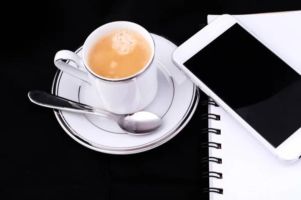 Eine Tasse Kaffee mit Notizblock und Smartphone. — Stockfoto