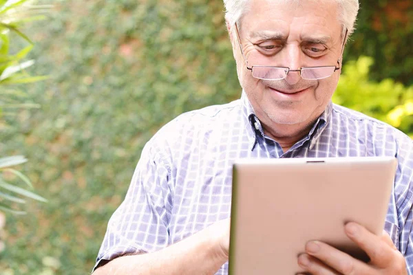 Homem velho usando tablet digital . — Fotografia de Stock