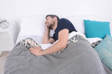 Adam yatakta uyuyor..