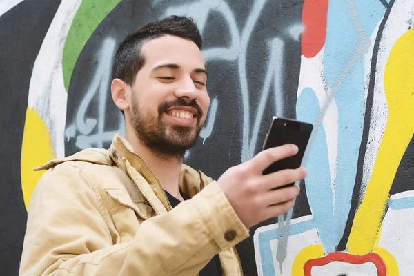 Latijnse man op zijn telefoon te typen. — Stockfoto