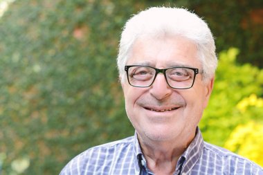 Dışında oturan yaşlı bir adam.