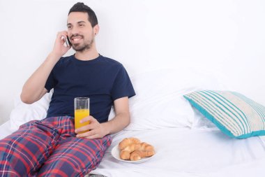 Yatakta telefonda konuşan adam.