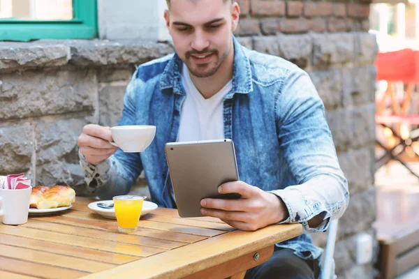 Genç adam kafe Cafe tablet kullanma. 