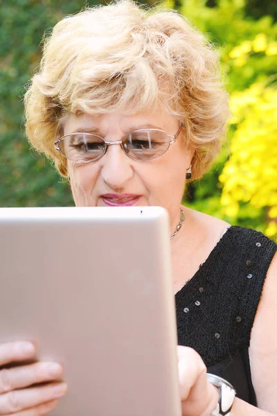 Bejaarde vrouw met behulp van Tablet PC. — Stockfoto