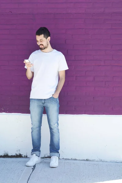 Hombre latino escribiendo en su teléfono . — Foto de Stock