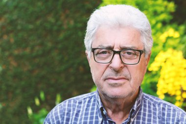 Dışında oturan yaşlı bir adam.