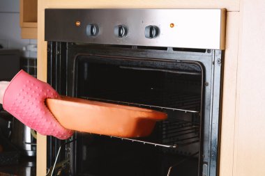 Mutfak eldiven ile fırın dışarı alarak fırında tepsi