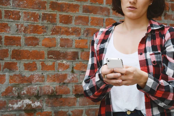 Junge Frau verschickt Nachrichten mit ihrem Smartphone. — Stockfoto