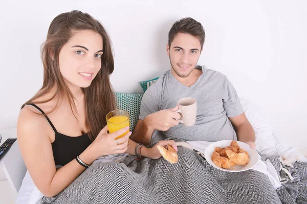 Çift yatakta kahvaltı yapıyor..