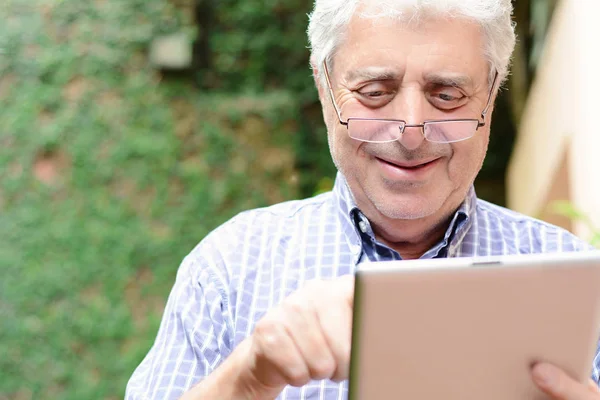 Homem velho usando tablet digital . — Fotografia de Stock