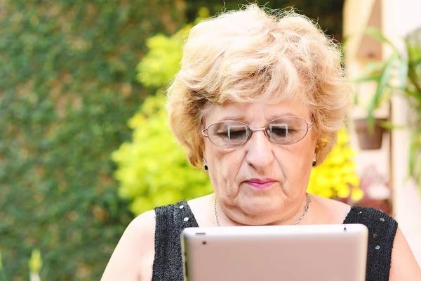Пожилая женщина с помощью планшета . — стоковое фото