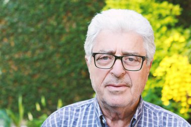 Dışında oturan yaşlı bir adam.