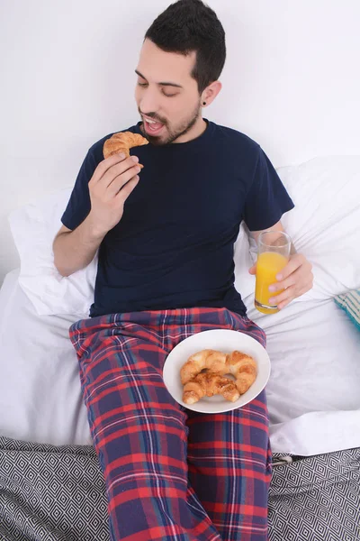 Adam yatakta kahvaltı yapıyor..