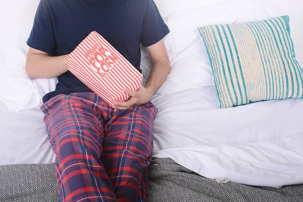 Patlamış mısır yemek ve film izlerken bir adam.