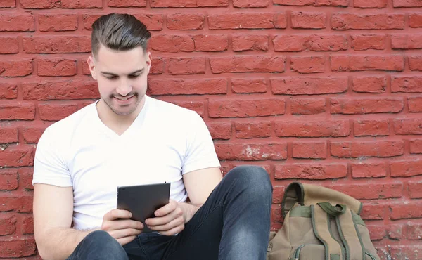 Hombre latino joven usando un comprimido —  Fotos de Stock