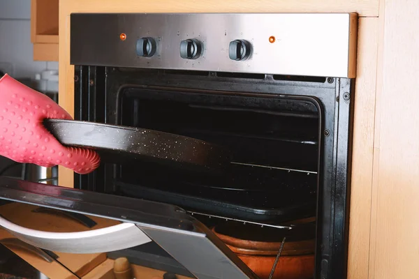 Tomar bandeja horneada del horno con guantes de cocina — Foto de Stock