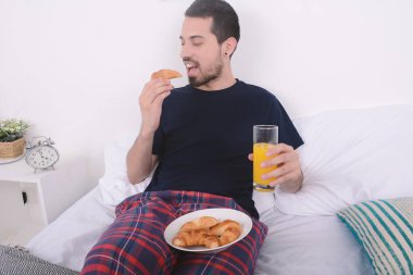 Adam yatakta kahvaltı yapıyor..